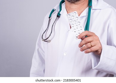 Senior Brazilian Doctor In White Coat, No Face, Holding Medicine Blister