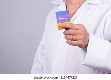 Senior Brazilian Doctor In White Coat, No Face, Holding Medicine Box