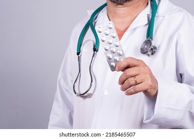 Senior Brazilian Doctor In White Coat, No Face, Holding Medicine Blister