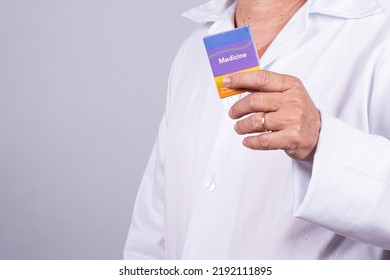 Senior Brazilian Doctor In White Coat, No Face, Holding Medicine Box