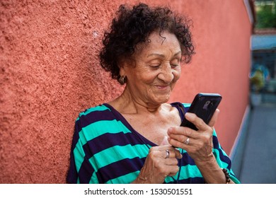 Senior brazillian reading a message on smartphone
