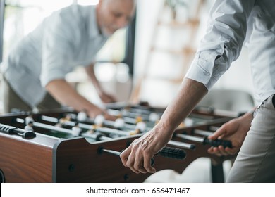 Senior Business Colleagues Playing Foosball At Office