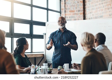 Senior business man doing presentation, planning and talking in a meeting, seminar or training workshop in a boardroom. Manager sharing ideas, teaching and coaching new employees during conference - Powered by Shutterstock