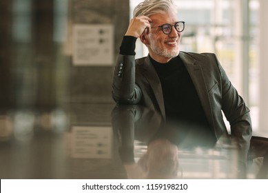 Senior Business Man Relaxing At Cafe. Mature Man Sitting At Coffee Shop Counter And Looking Away Smiling.