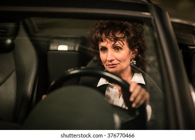 Senior Business Woman Driving Car At Night - Detail