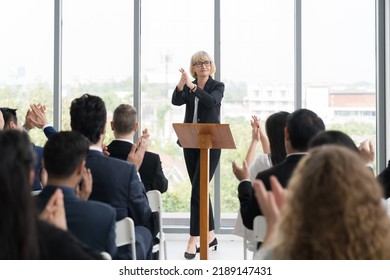 Senior business woman talking at podium speaker. Business people clapping hands to speaker at Business Conference - Powered by Shutterstock