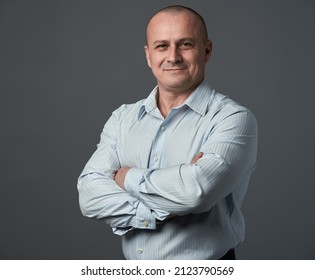 Senior businessman with arms crossed, over gray background - Powered by Shutterstock