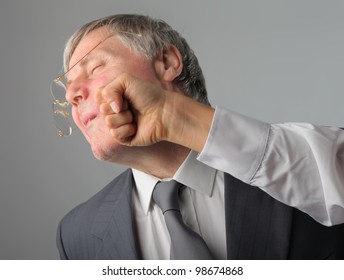 Senior Businessman Being Punched In The Face