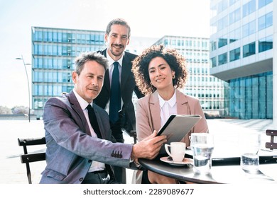 Senior businessman, caucasian man and beautiful hispanic businesswoman meeting in a bar restaurant  - Three colleagues bonding in a cafe after work - Powered by Shutterstock