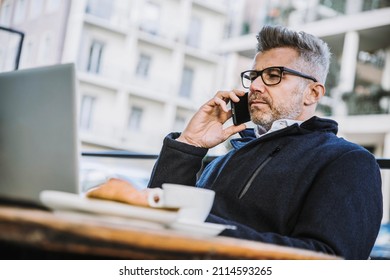 Senior Businessman In Coffee Shop Using Pc Laptop And Talking On Phone - Business Man Working On Computer Outside - Job, Entrepreneur And Communication Concept