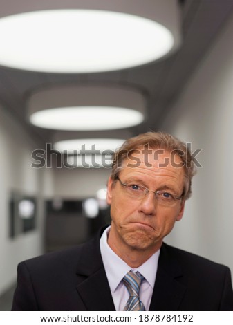 Similar – Image, Stock Photo A man looks down on three rows of arrows, one row of which points forward and the other two point against him.