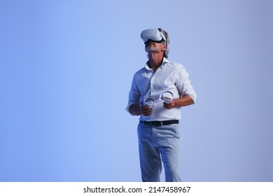 Senior businessman having a meeting in the metaverse. Mature businessman wearing a virtual reality headset in a studio. Businessman collaborating with his colleagues using immersive technology. - Powered by Shutterstock