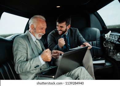 Senior businessman and his assistant sitting in limousine and celebrating their job success.  - Powered by Shutterstock