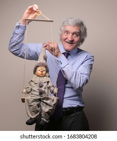 Senior Businessman With Marionette In His Hands