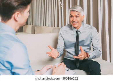 Senior Businessman Offering Proposal to Young Man