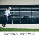 senior businessman in a rush  running and using a phone smartphone outdoors