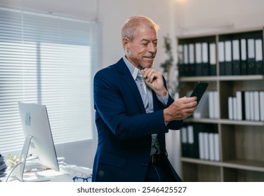 Senior businessman in a suit is using his smartphone in a modern office, thoughtfully reading news or messages with a contemplative expression - Powered by Shutterstock