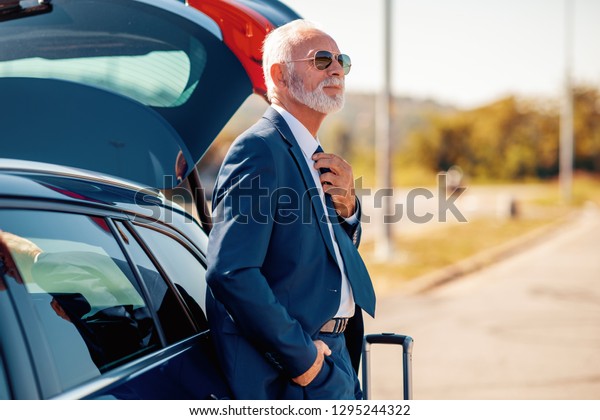 Senior businessman traveling to work wit\
car,having little break.