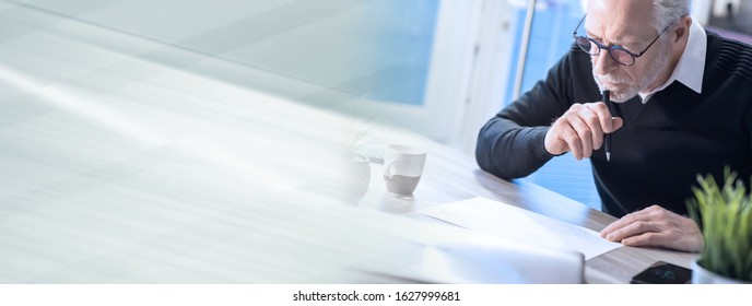 Senior businessman working on document at office; panoramic banner - Shutterstock ID 1627999681