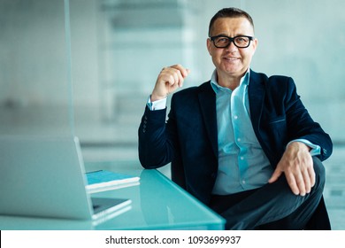 Senior Businessman Working On Laptop Computer In Office