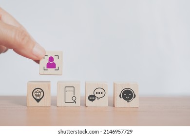senior businessman's hand hold person in crop icon on wooden cube block  over the others for buyer persona and target customer concept, buyer or customer psychology profile or characteristics