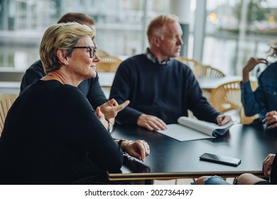 Senior businesswoman sitting in boardroom meeting. Group of business people having a meeting in office. - Shutterstock ID 2027364497