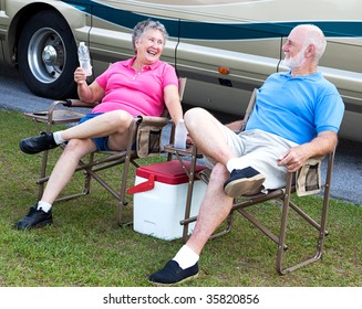 Senior campers sitting in folding chairs outside their motor home. - Powered by Shutterstock