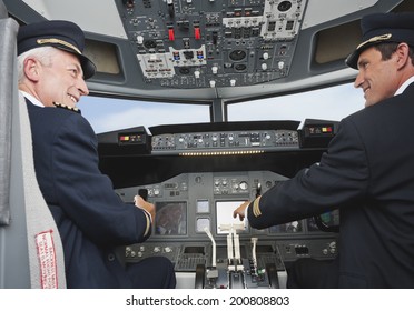 Senior captain and co-pilot driving airplane in cockpit