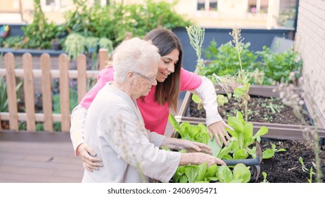 Senior and caregiver removing soil of plants of a geriatric