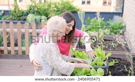 Senior and caregiver removing soil of plants of a geriatric