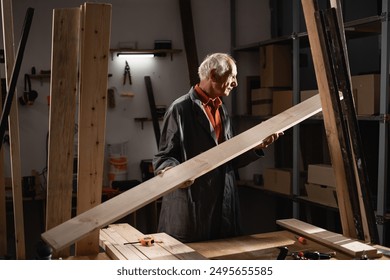 Senior carpenter inspecting a wooden plank in his workshop, carefully examining the wood quality for his next project - Powered by Shutterstock