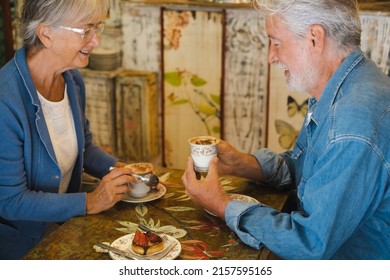 Senior Caucasian Couple At Cafe Shop Having Break Together. White Haired Elderly People Denim Dressed Smiling Happy