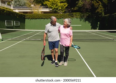 Senior caucasian couple embracing and smiling on tennis court. retirement retreat and active senior lifestyle concept. - Powered by Shutterstock