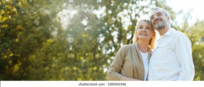 Senior Caucasian couple hugging in park. Family with a happy smile feels relaxed with nature in the morning. Or in the evening. Enter  elderly society And retire from work. Concept health insurance
