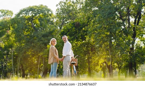 Senior Caucasian couple hugging in park. Family with a happy smile feels relaxed with nature in the morning. Or in the evening. Enter elderly society And retire from work. Concept health insurance