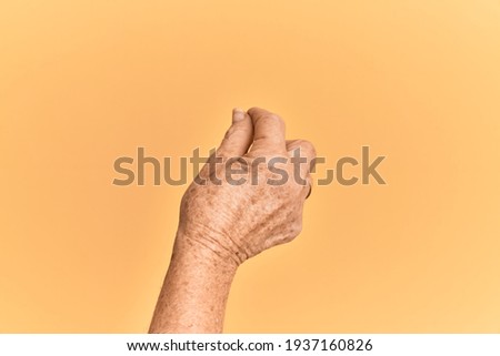 Senior caucasian hand over yellow isolated background holding blank space with thumb finger, business and advertising 