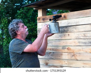 Senior caucasian man burning a board with a blowtorch - Powered by Shutterstock