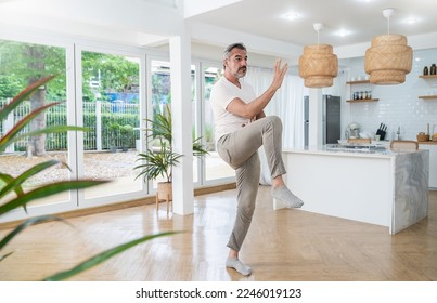 Senior caucasian man doing exercise tai chi gym at home. Chinese management skill energy. Mature old man play tai chi. Healthcare meditation yoga skill. Activity hobby leisure time for retire people. - Powered by Shutterstock