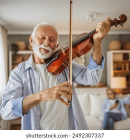 senior caucasian man learn to play violin practice at home - Powered by Shutterstock