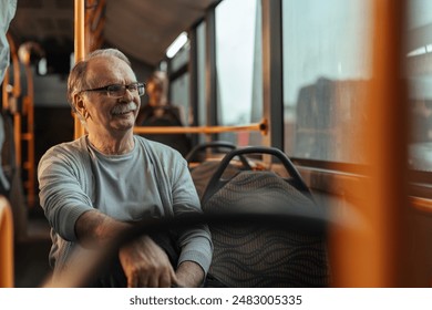 Senior Caucasian man with a mustache is sitting on a bus with smirk on his face with copy space. - Powered by Shutterstock