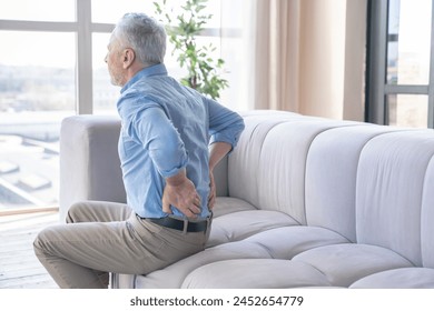 Senior caucasian old elderly man suffering from back pain at home. Rheumatism, ache, health problems. Sedentary lifestyle. People, healthcare and problem concept - Powered by Shutterstock