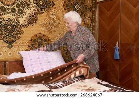 Similar – Caregiver making bed of elderly patient in nursing home