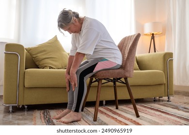 Senior caucasian woman doing doing yoga at home on sofa - Powered by Shutterstock