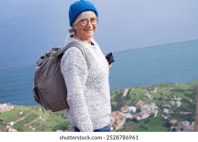 Senior caucasian woman on the top of mountain in La Gomera island enjoying travel, adventure freedom and nature. Elderly active woman on a leisure trip looking at camera - Powered by Shutterstock