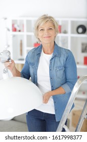 senior changing to more efficient light bulb