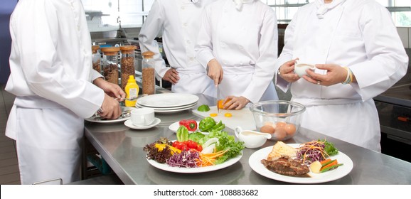 A Senior Chef Giving Cooking Lesson To Young Chefs