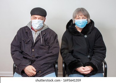 Senior Citizen Couple Wearing Face Masks In Waiting Room