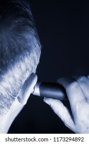 Senior Citizen Man Cutting Inner Ear Hair With Electric Cutter.