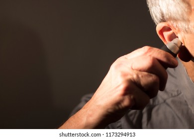 Senior Citizen Man Cutting Inner Ear Hair With Electric Cutter.