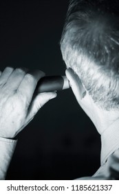 Senior Citizen Man Cutting Inner Ear Hair With Electric Cutter.